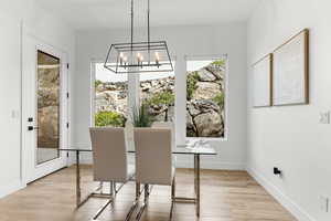 Dining space with hanging lights and light wood-style flooring