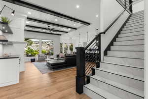 Staircase with wood finished floors, a ceiling fan, recessed lighting, and a wooden ceiling with exposed beams