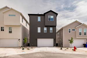 View of front facade featuring driveway and an attached garage