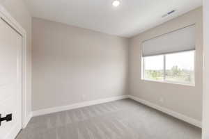 Unfurnished bedroom with baseboards and light colored carpet