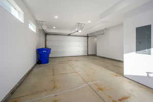 Garage featuring electric panel and recessed lighting