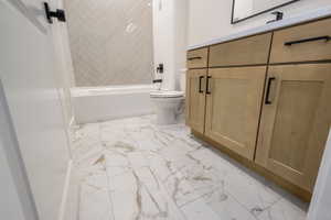 Bathroom with vanity,  shower combination, and light marble finish flooring