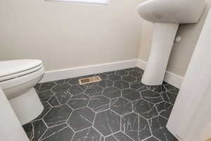 Bathroom featuring toilet and baseboards