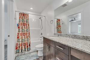 Bathroom featuring vanity, shower / bath combo, recessed lighting, and ceiling fan