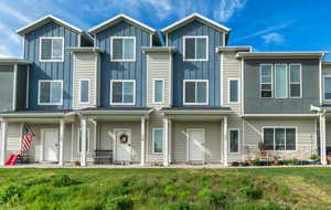 Contemporary house with board and batten siding, a front yard, and stone siding