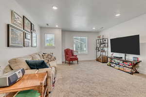 Carpeted living area featuring recessed lighting and a textured ceiling