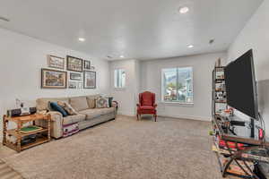 Living area featuring light colored carpet and recessed lighting
