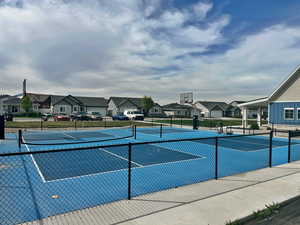 View of tennis court featuring a residential view and community basketball court