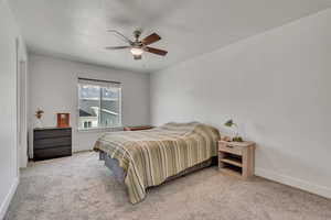 Bedroom with light carpet and a ceiling fan