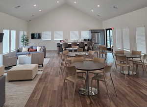 Dining area with a high ceiling, recessed lighting, and wood finished floors