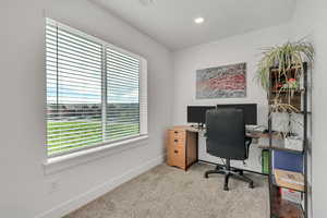 Office with light colored carpet and recessed lighting