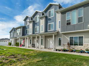 Modern home with board and batten siding, covered porch, and a front lawn
