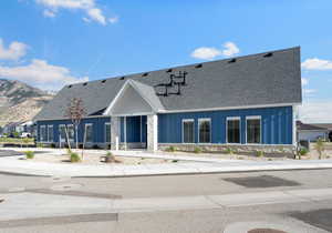 View of front of house featuring board and batten siding, a shingled roof, and a mountain view