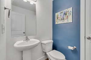 Half bathroom with toilet and baseboards