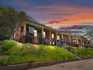 View of front of house with a porch and brick siding