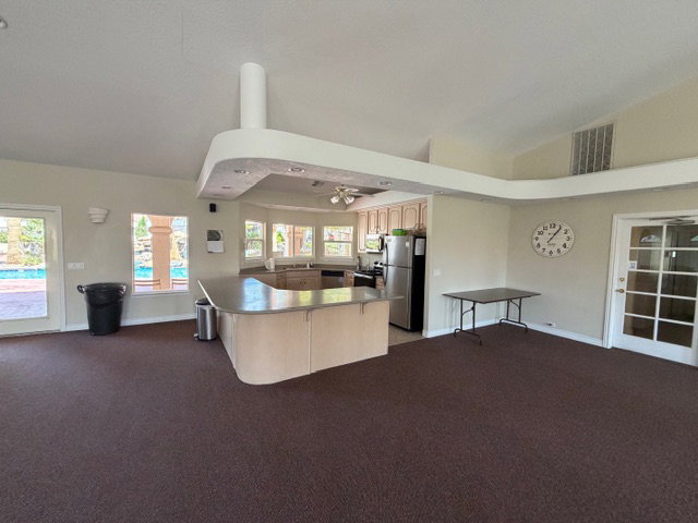 Kitchen with open floor plan, stainless steel appliances, vaulted ceiling, and ceiling fan