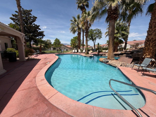 Community pool with a patio area and a residential view