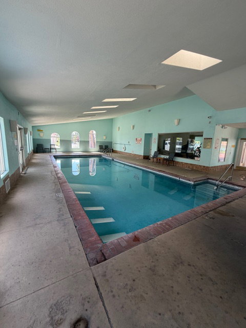 Indoor community pool featuring a skylight