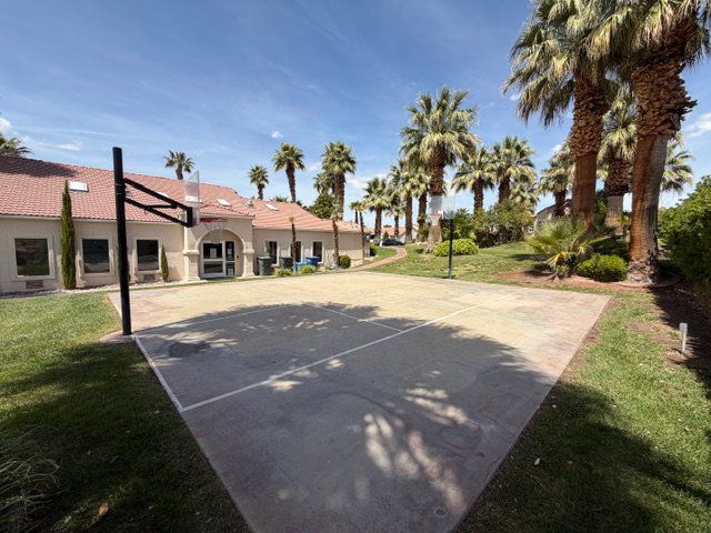 View of sport court featuring community basketball court and a lawn