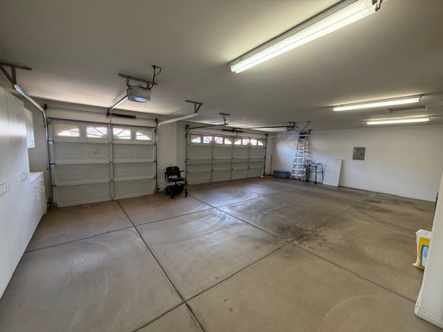 Garage featuring a garage door opener and electric panel