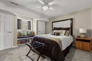 Bedroom with carpet, a textured ceiling, and ceiling fan