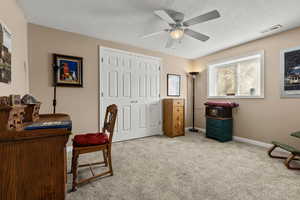 Office featuring light carpet, ceiling fan, and a textured ceiling