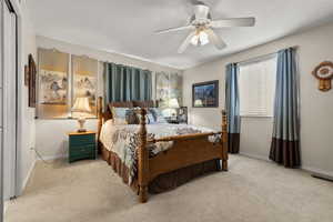 Bedroom with a ceiling fan and light colored carpet