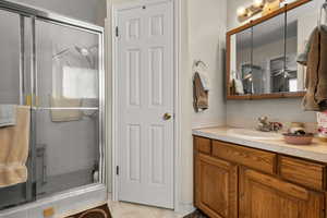 Bathroom featuring vanity, a stall shower, and light tile patterned floors