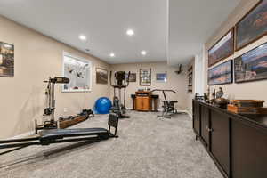 Exercise room with light colored carpet and recessed lighting
