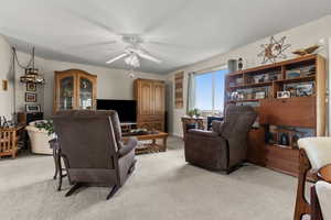 Living room with light carpet and a ceiling fan