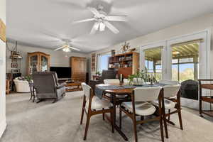 Dining space featuring light carpet and ceiling fan
