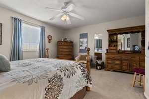 Bedroom featuring light colored carpet and a ceiling fan