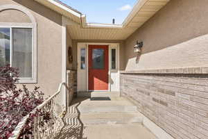 Doorway to property featuring stucco siding
