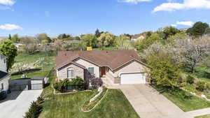 Ranch-style house with a gate, a garage, driveway, and brick siding