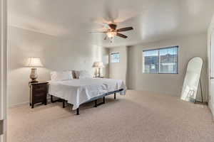 Bedroom featuring light carpet and a ceiling fan