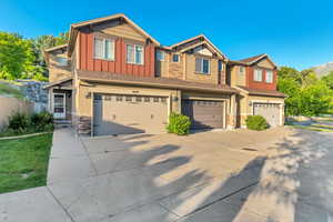 Craftsman house with board and batten siding, stone siding, a garage, and concrete driveway