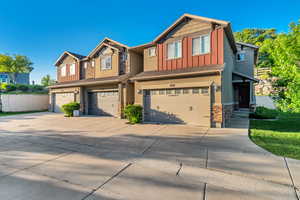 Craftsman house with stone siding, board and batten siding, a garage, and concrete driveway