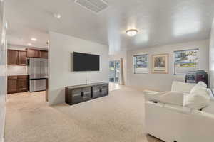 Living area featuring light carpet and baseboards