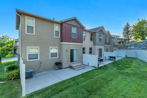 Rear view of property featuring a patio, board and batten siding, and stucco siding