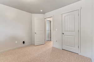 Unfurnished bedroom featuring light colored carpet and baseboards