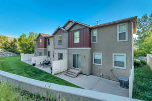 Back of property with a patio area, board and batten siding, and stucco siding