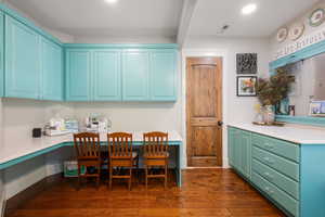 Dining room featuring built in study area, dark wood finished floors, and recessed lighting