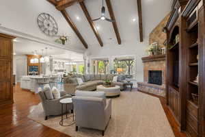 Living area featuring a fireplace, dark wood-style flooring, a ceiling fan, recessed lighting, and vaulted ceiling