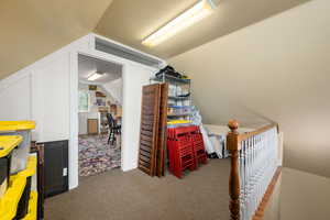 Interior space featuring carpet flooring and vaulted ceiling