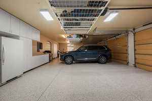 Garage featuring freestanding refrigerator and electric panel