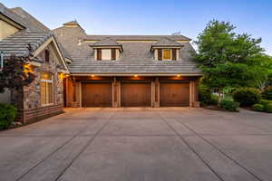 View of front of home featuring driveway, an attached garage, and stone siding