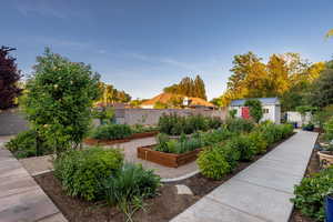 Fenced backyard with a garden and a shed