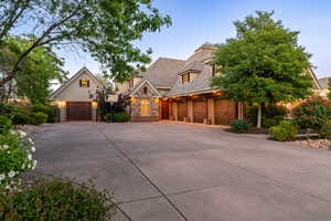 View of front of house with stucco siding, stone siding, and concrete driveway