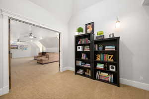 Living area with vaulted ceiling, light carpet, and ceiling fan