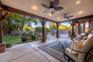 Fenced backyard featuring a patio area, an outdoor living space, and a ceiling fan